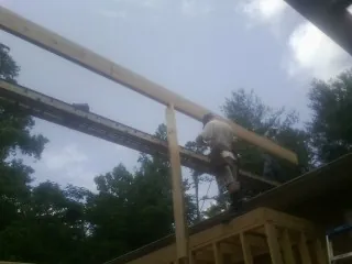 Carpenter setting a ridge beam over a new addition frame — Ice Dam Removal by Roofing Brothers in Monrovia